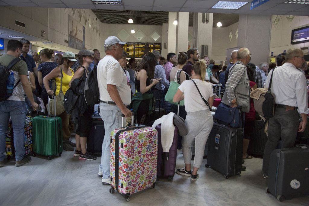 Passengers stand in line to check-in at Heraklion International Airport, Greece. Thomas Cook has gone into liquidation.