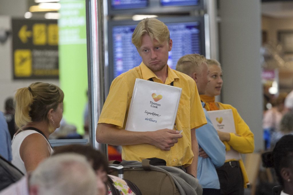A Thomas Cook staff member looks forlorn while speaking with a passenger following the company's collapse.