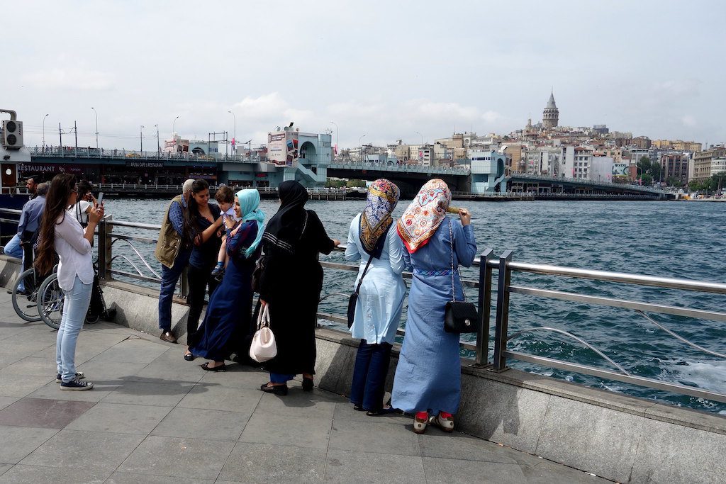 Middle Eastern tourists have high per-outbound-trip expenditures. Here, Muslim women take pictures by water.