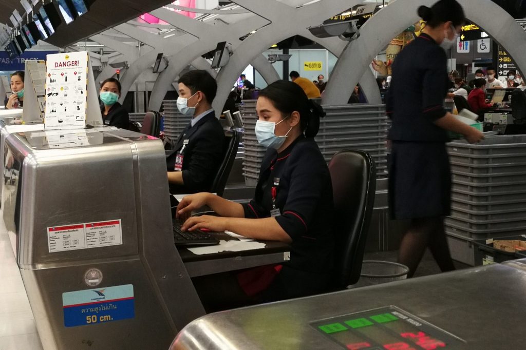 Airport staff don face masks at Bangkok's Suvarnabhumi.