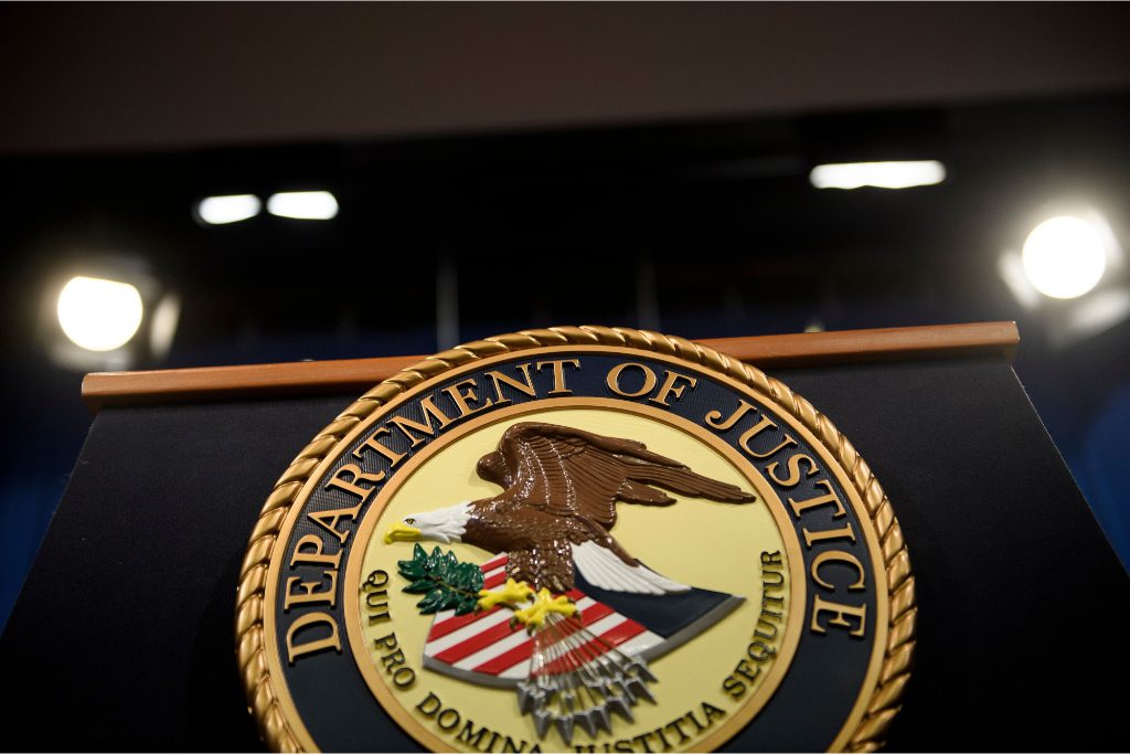 An image of a speaker's dais at the U.S. Department of Justice. On Monday, a Delaware court began hearing arguments in the U.S. Department of Justice's antitrust lawsuit against Sabre over an acquisition.