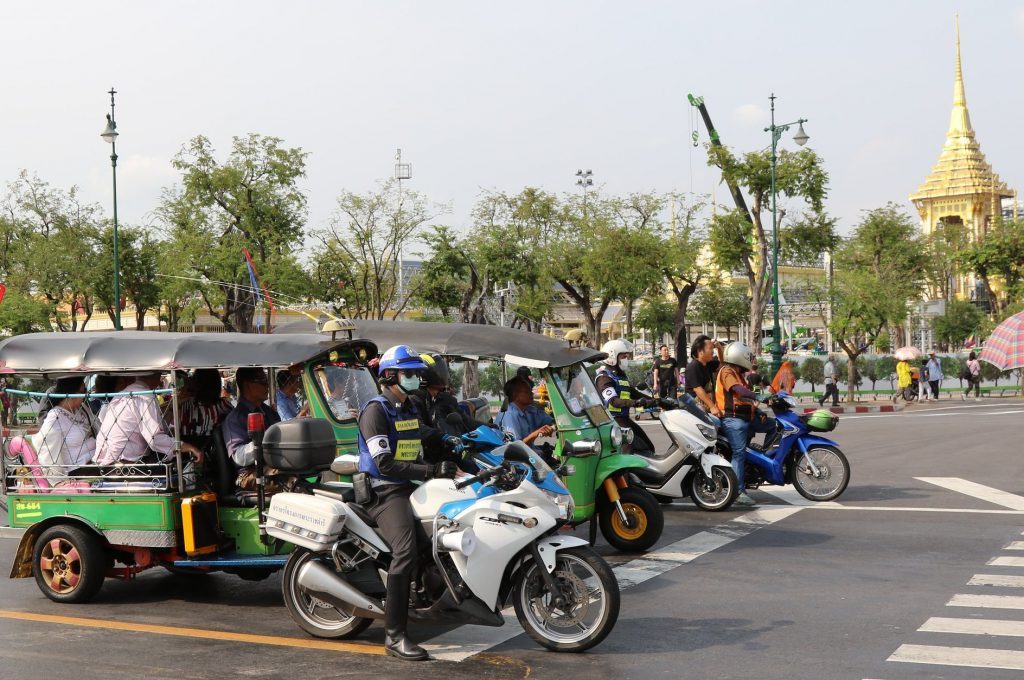 Motorists and tuk-tuks at a traffic junction in Bangkok.
