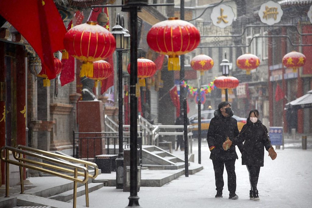 A couple wearing face masks walk along a deserted pedestrian shopping street during a snowfall in Beijing. Travel advisors have had to step up and manage their clients' increasingly growing concerns over the coronavirus outbreak.
