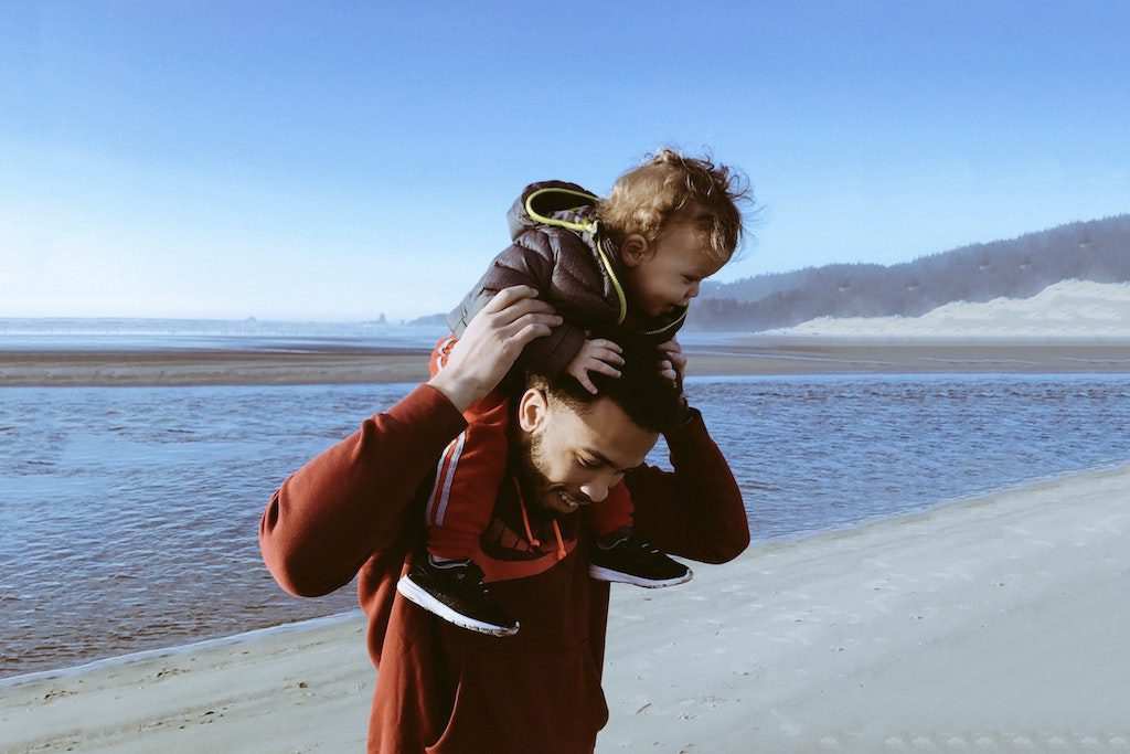 Most millennials today are parents, and they're changing family travel. A young dad plays with his son on the beach.