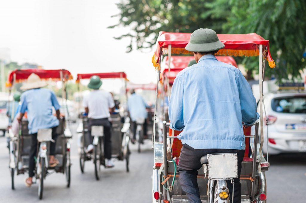 Small players in the travel industry are especially hard hit by the coronavirus crisis as tour bookings demand dries up. Traditional cyclos ride down the streets of Hanoi, Vietnam.