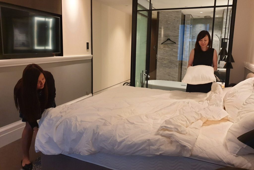 Staff of Singapore's Park Hotel Group preparing a hotel room for guests following a last-minute surge in bookings due to Malaysia's lockdown.