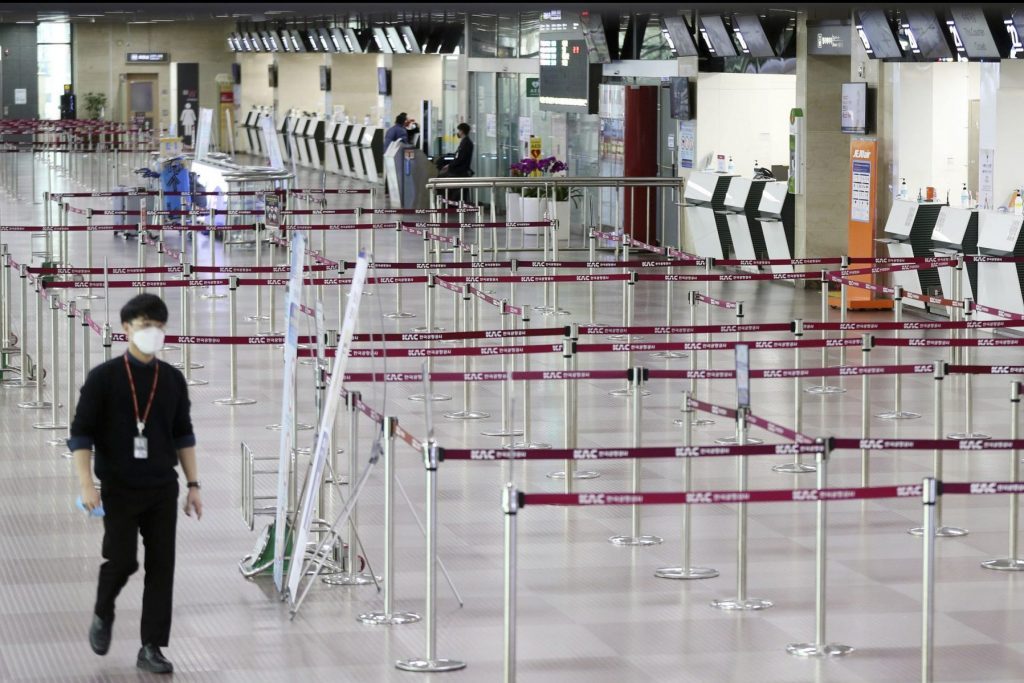 A man wearing a face mask passes by empty ticket counters at the Daegu Airport in Daegu, South Korea. The coronavirus outbreak has caused a sharp slowdown in global business travel as more companies suspend or cancel travel due to Covid-19 concerns. 