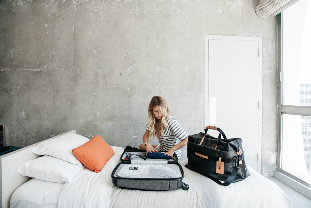 A model pretends to pack for a trip. After all, there's nowhere to go during a pandemic.