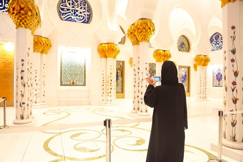 A Muslim traveler taking picture of the Sheikh Zayed Grand Mosque in Abu Dhabi.