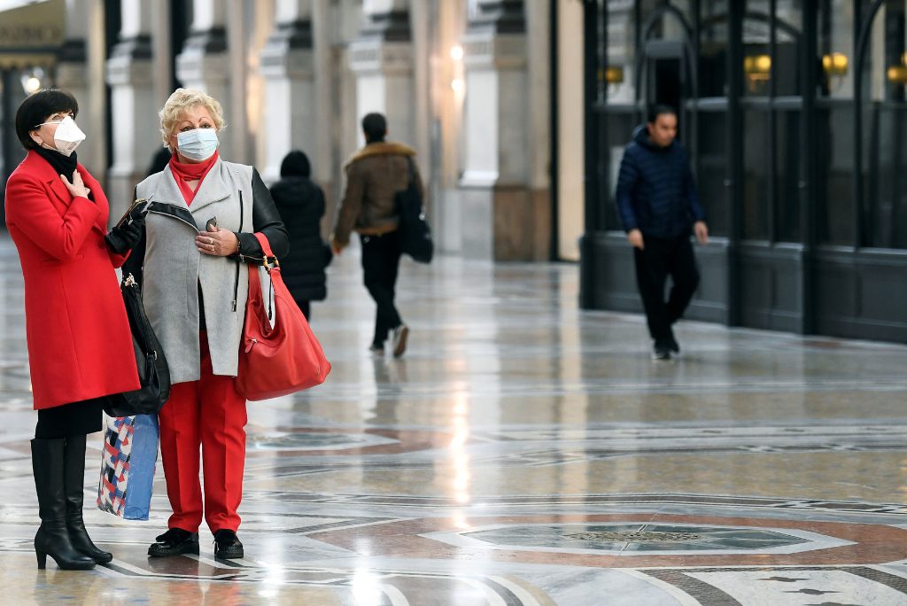 Women in face masks are seen in Galleria Vittorio Emanuele II, after the Italian government imposed a virtual lockdown on the north of the country, in Milan, Italy March 8, 2020.