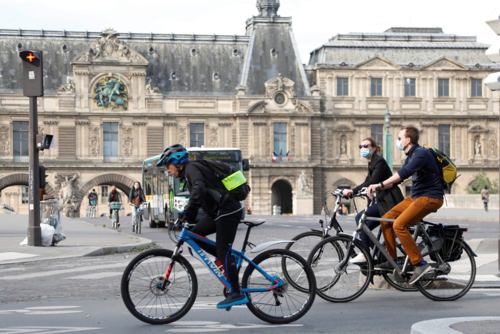 Bikers ride past the Louvre museum after France began a gradual end to a nationwide lockdown due to the coronavirus disease, in Paris, May 13, 2020.