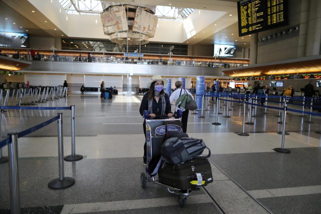 A woman walks through an international terminal at Los Angeles International Airport on March 11, 2020. 