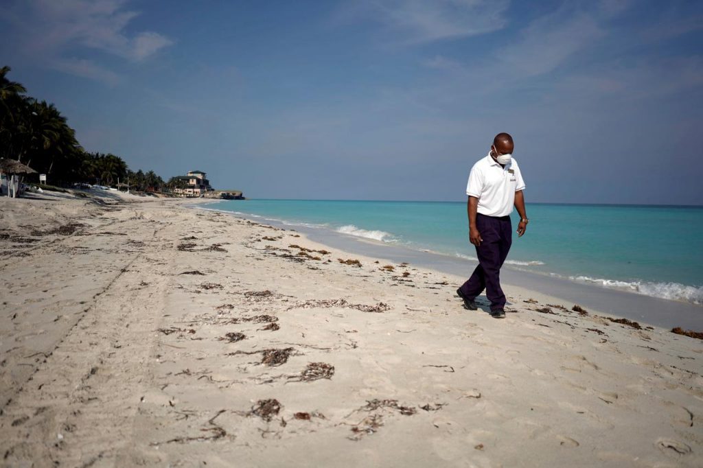 A security agent wearing a protective mask walks on the beach in Varadero, Cuba.