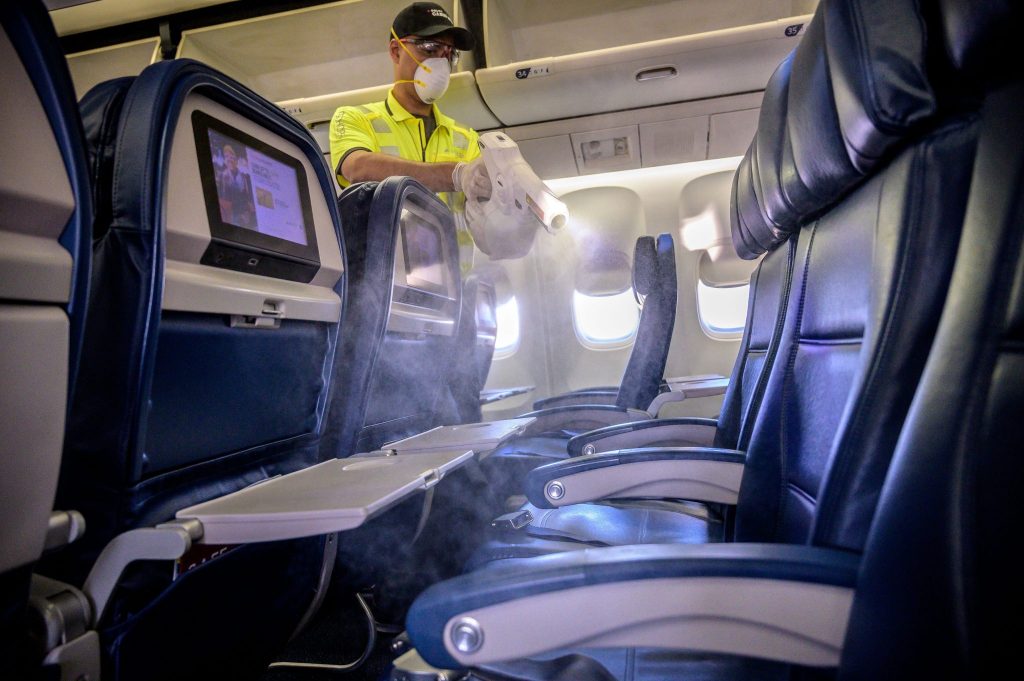 Members of Delta's line maintenance crew disinfect the surfaces of the cabin including tray tables, seat backs and in-flight entertainment screens in a Boeing 757 in Atlanta. 