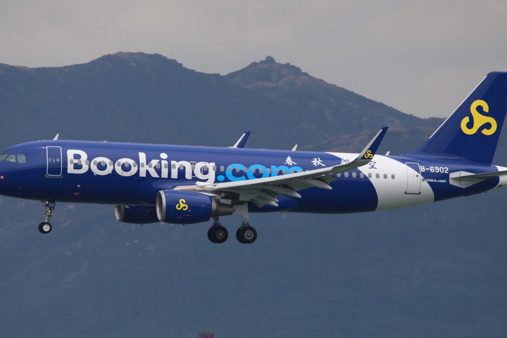 Pictured is a Spring Airlines A320 bedecked as Booking.com as seen on July 7, 2018. Booking sees flights as key to its connected trip strategy.