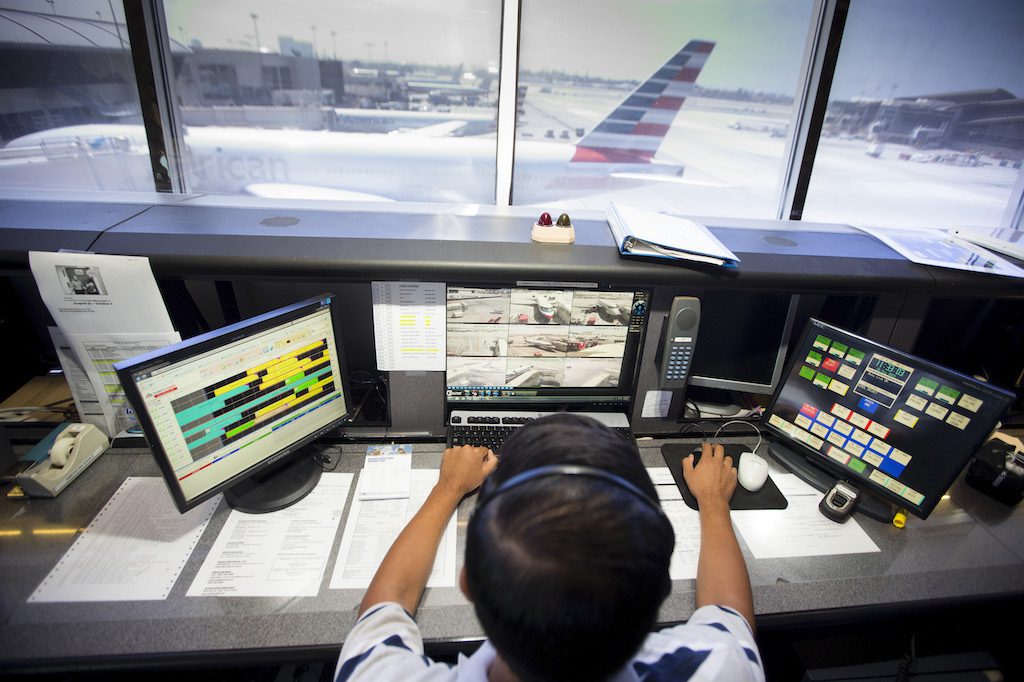 An American Airlines employee watches over jets in Los Angeles. American will shrink its presence in L.A. 