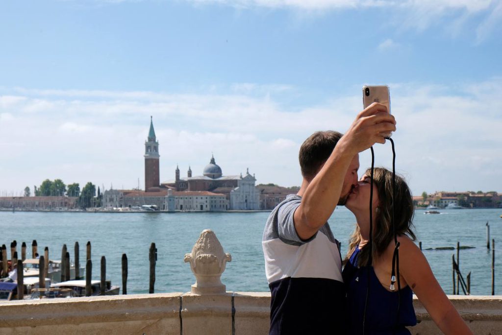 Tourists take a selfie a day before Italy and neighboring EU countries open up borders for the first time since the coronavirus disease  outbreak hit the country, in Venice, Italy June 14, 2020. 