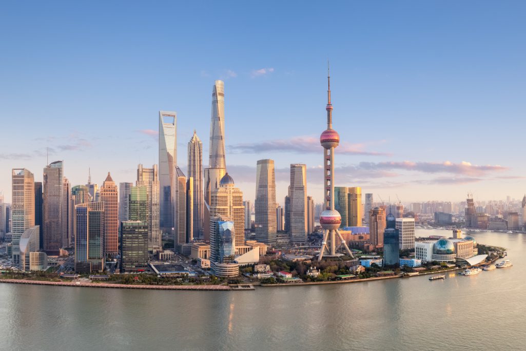 The Shanghai skyline as a panorama at sunset, featuring the Pudong Financial Center along the Huangpu Fiver in China.