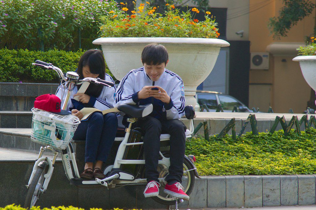 Asian travlers on mobile phones in Hanoi. 