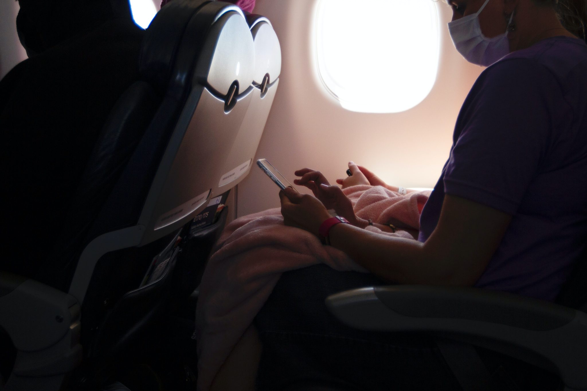 A passenger on a plane wearing a facemask. A study published in March highlighted the effectiveness in airport rapid testing to slow the spread of the coronavirus. 