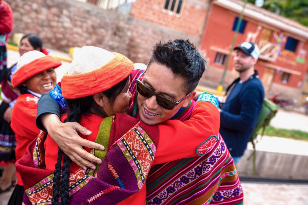 Peru Sacred Valley Ccaccaccollo Woman from Women Weaving Co-op Weaver Embracing Bruce Poon Tip