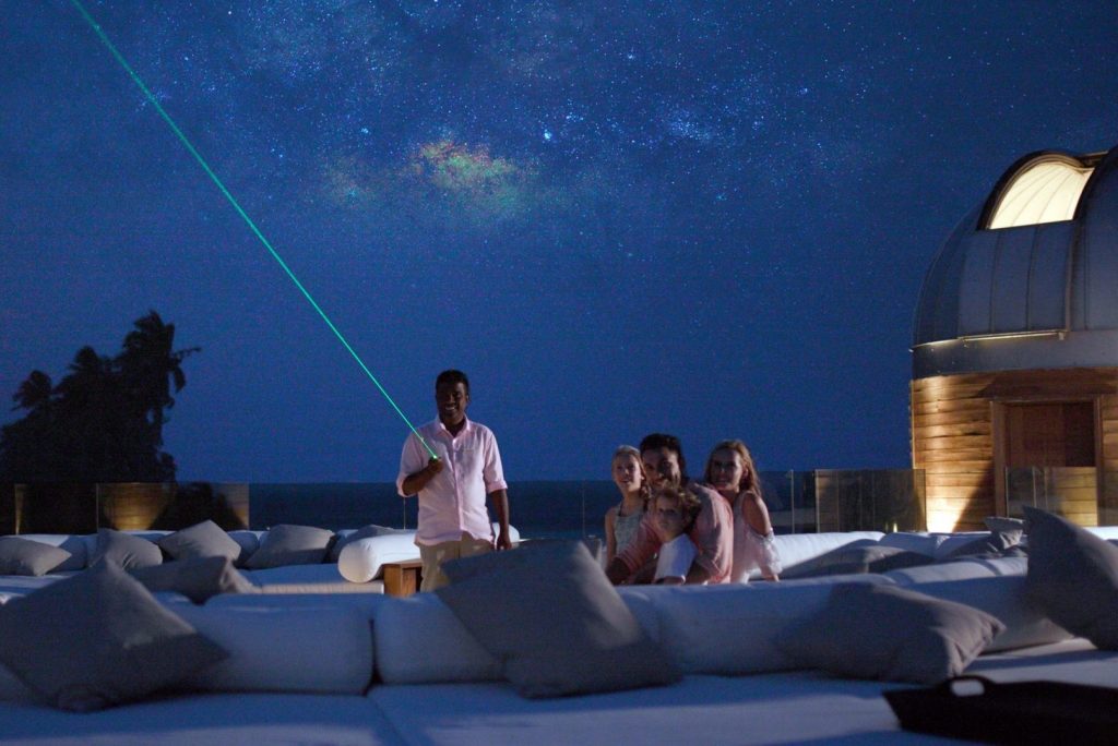 Using a laser, the Sky Guru points out stars and planets to Anantara Kihavah resort guests. 
