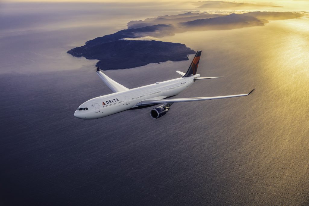 A Delta Airbus 330-300 flying over an ocean at sunset. Delta announced Monday it had signed a new distribution contract with  Sabre, a travel tech company.