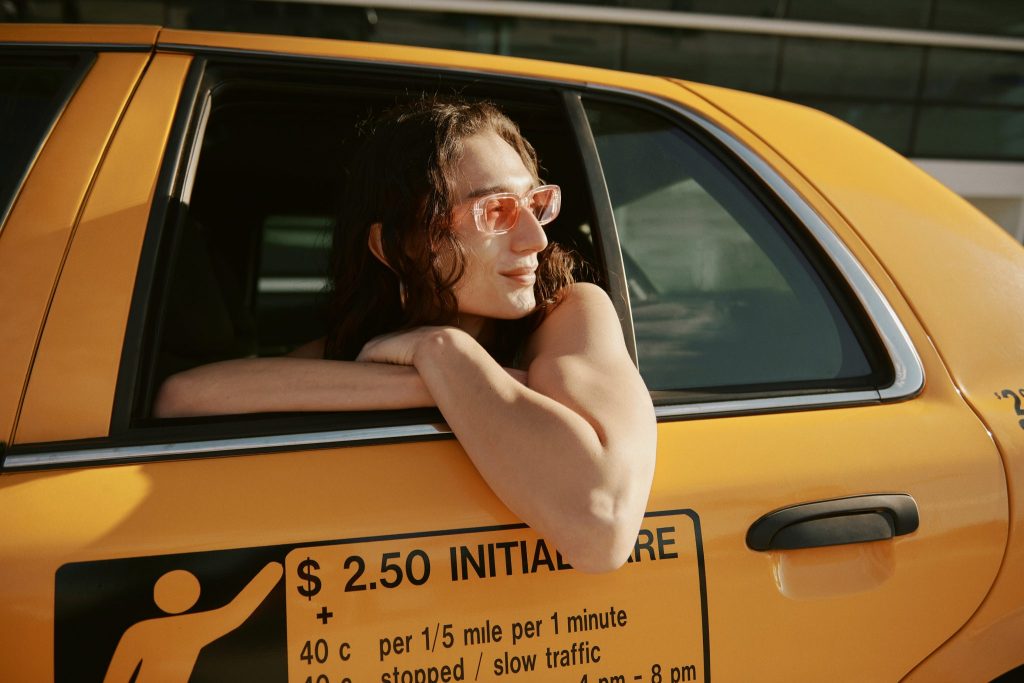A non-binary person in a taxi cab as part of Orbitz's new LBTQIA+ 'Travel As You Are Campaign.'