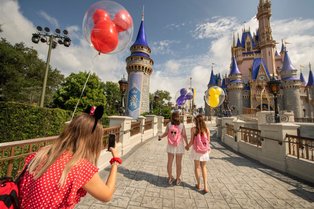 Guests stop to take a photo at Magic Kingdom Park, July 11, 2020, at Walt Disney World Resort in Lake Buena Vista, Florida, on the first day of the theme park’s phased reopening.