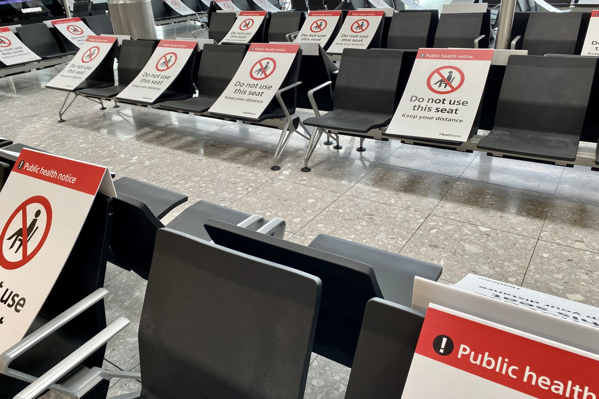 Social distancing warnings on chairs at London's Heathrow airport in July 2021. New restrictions may see the return of similar measures. 