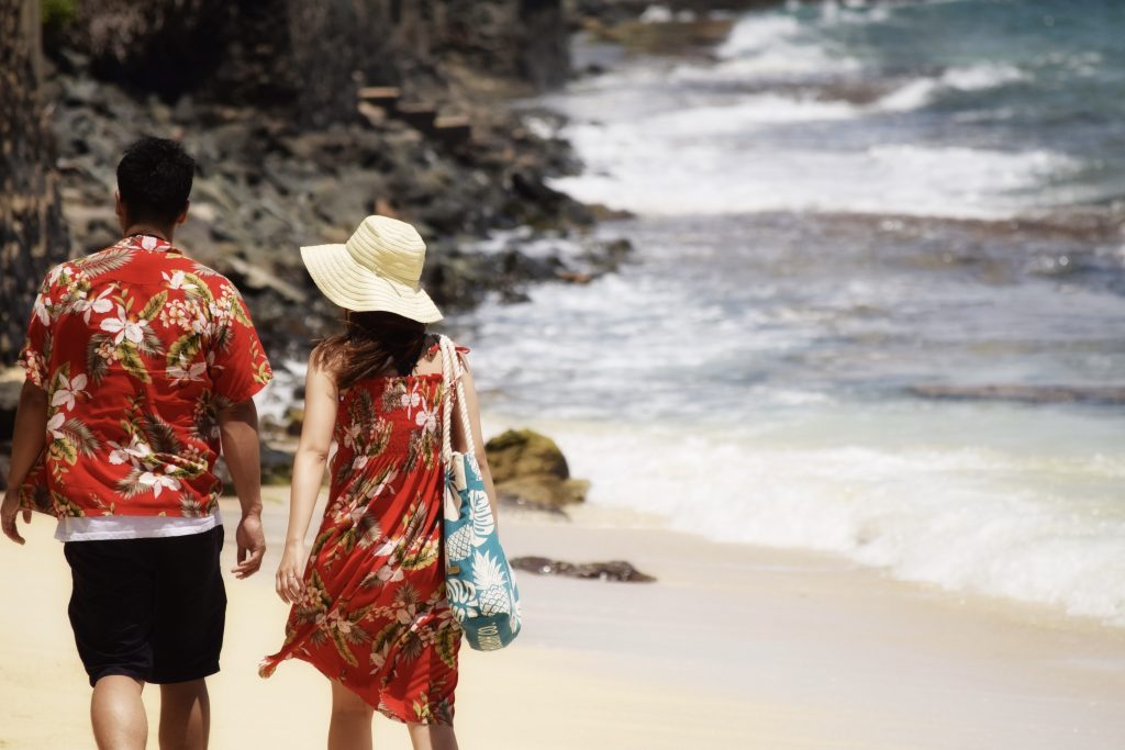 A couple walks along a beach near Honolulu, Hawaii. 