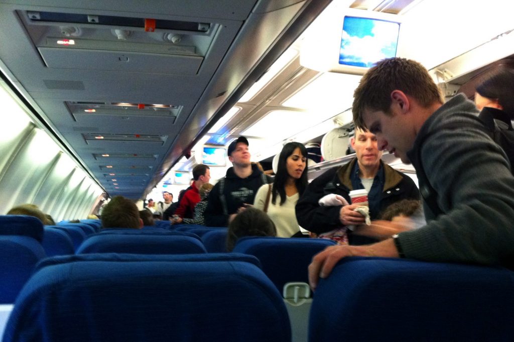 Passengers are boarding a flight in this scaled photo as the U.S. government fines for unruly passenger behavior are rising.