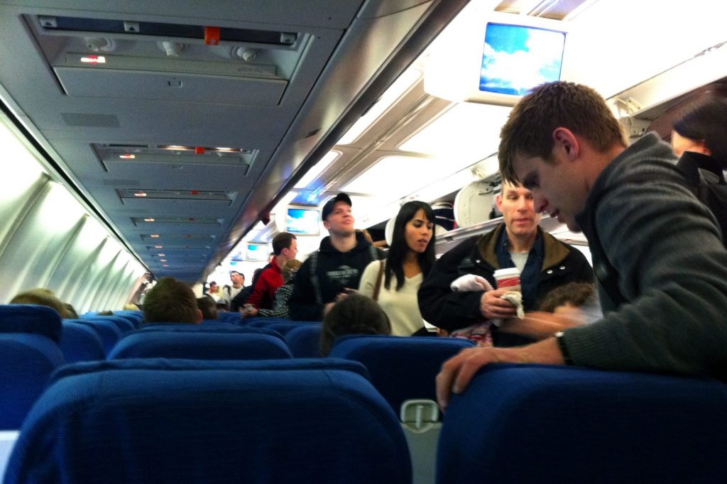 Passengers are boarding a flight in this scaled photo as the U.S. government fines for unruly passenger behavior are rising.