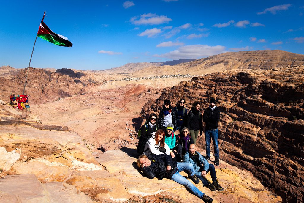 travel group posing on top of cliff