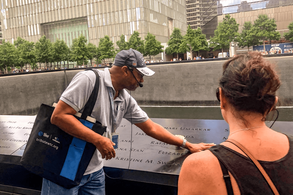A guide at the September 11 Memorial points to the names of those who died that day. 