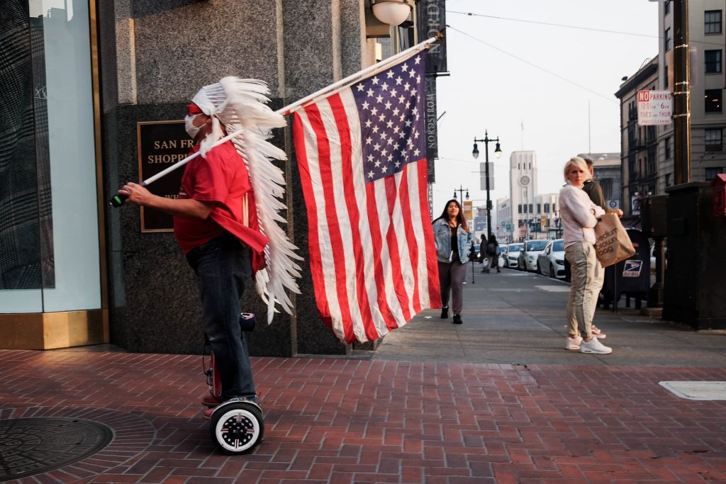 native american holding usa flag in street san francisco