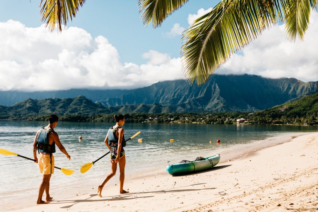 Two kayakers walking on beach in Oahu Hawaii