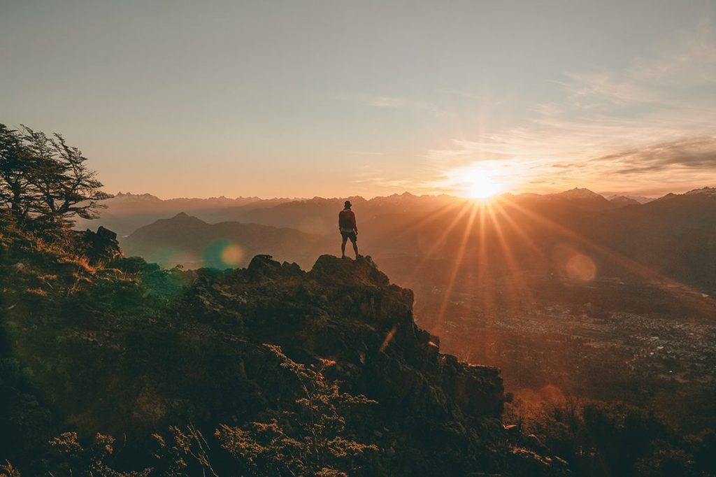 person looking at a sunset on a mountain