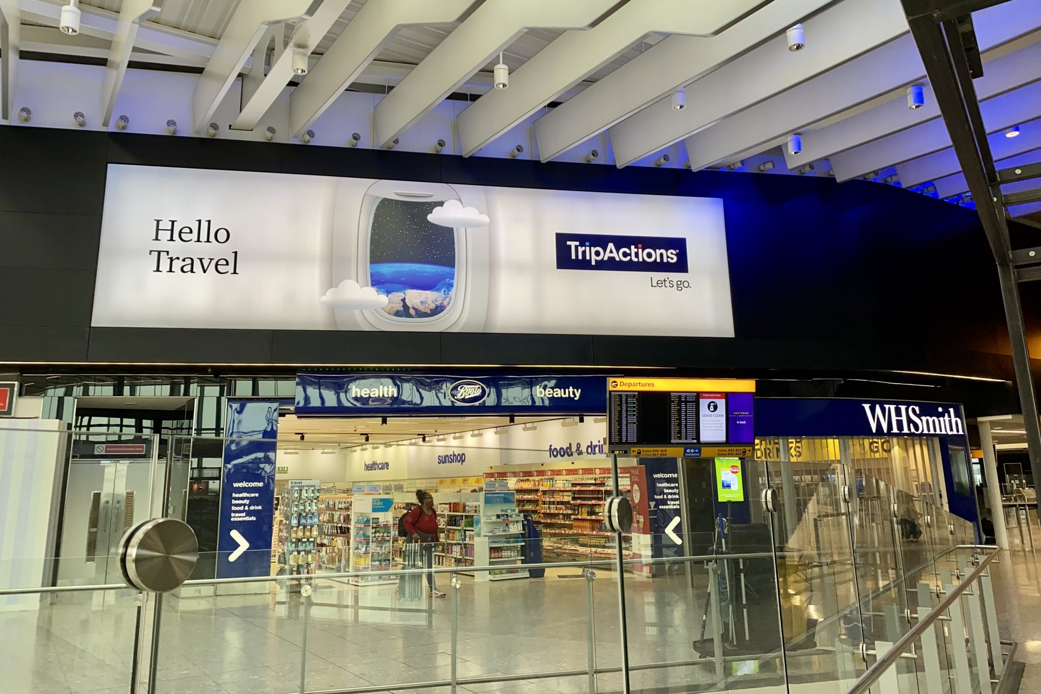 A TripActions ad above an airport bookstore at Heathrow International Airport. 