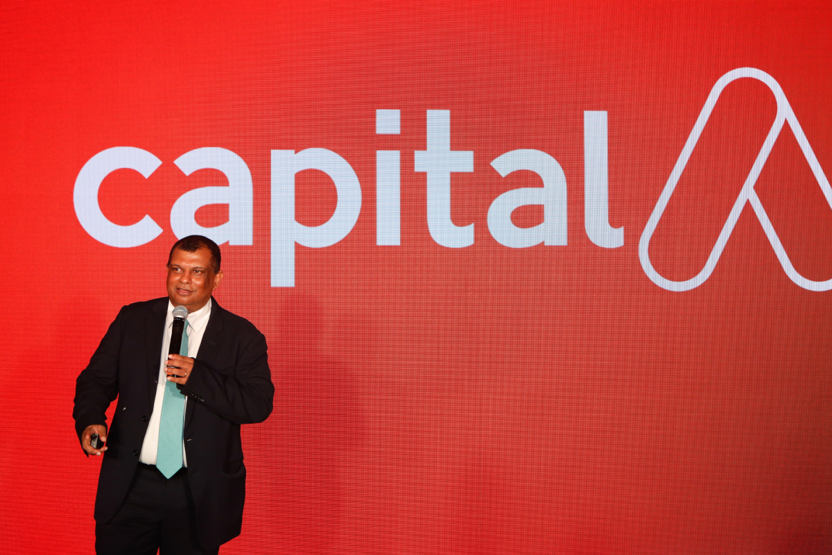AirAsia CEO Tony Fernandes in front of new corporate logo.