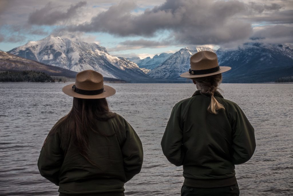 Two national park rangers look at the weather at McDonald Lake at Glacier National Park in November 2018.