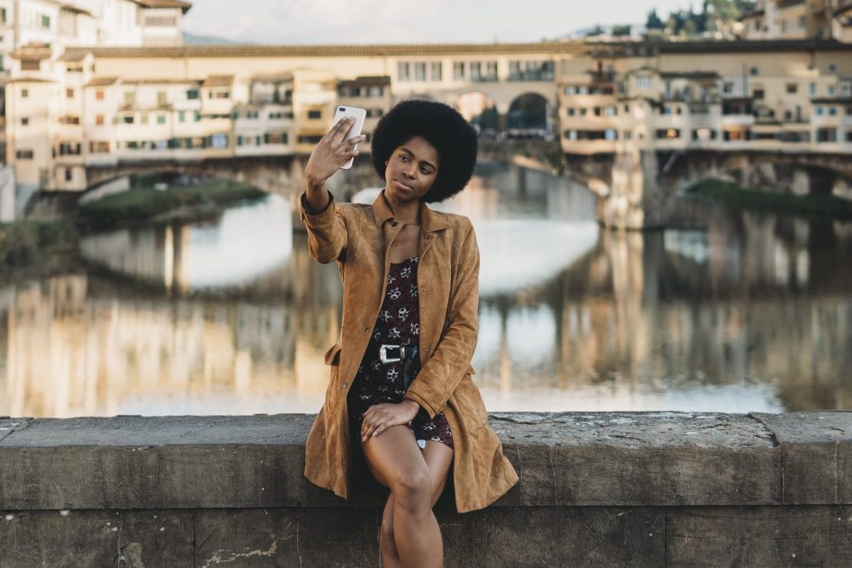 Young woman taking selfie on bridge in Florence, Italy