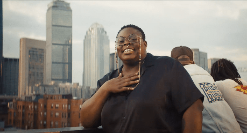 black woman on rooftop with boston skyscrapers