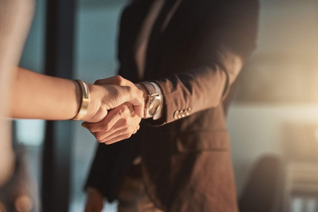 Two conference attendees shaking hands.