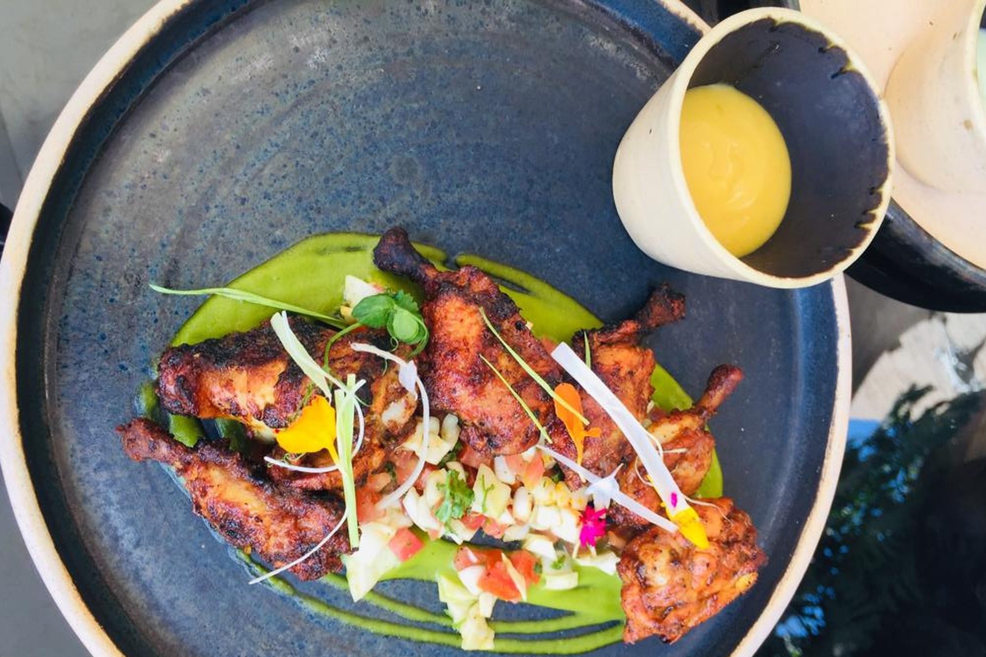 Grilled chicken wings made with mitmita spices, zatar and served with tomato, mango dip and kachumbari salad at the Tribe Hotel. Kachumbari is a common dish in Kenya