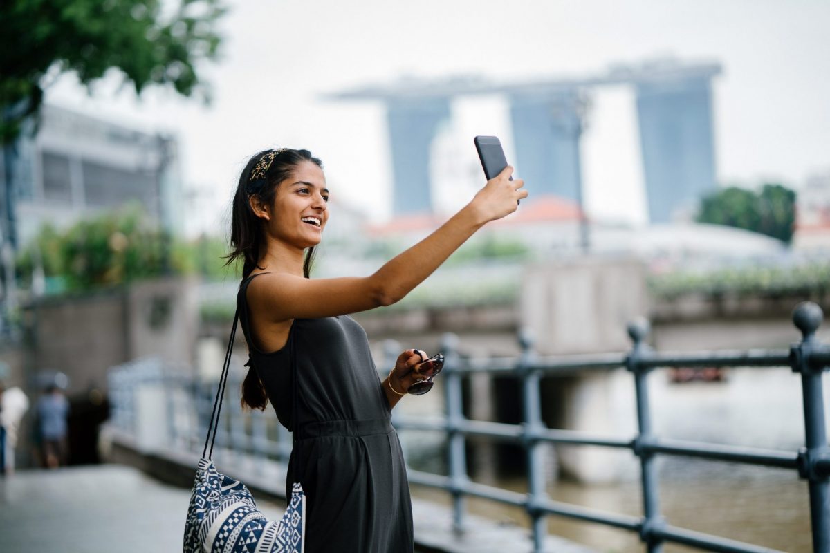 A young Indian lady taking selfie in Singapore's downtown.