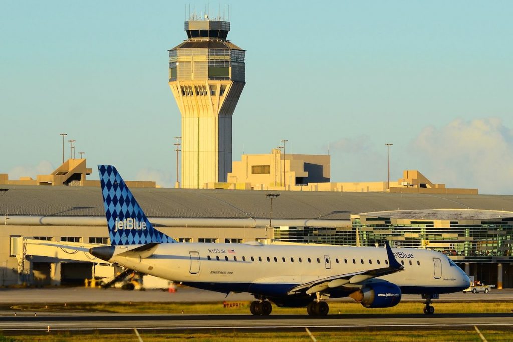 A JetBlue plane taxis past the control tower at San Juan airport