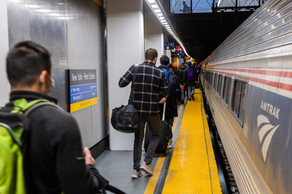 Travelers board an Amtrak train in New York