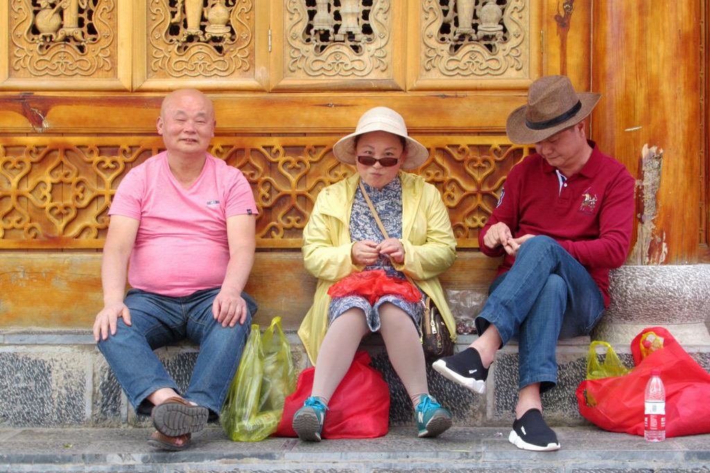 A trio of Chinese tourists take a break in Lijiang, Yunnan, China.