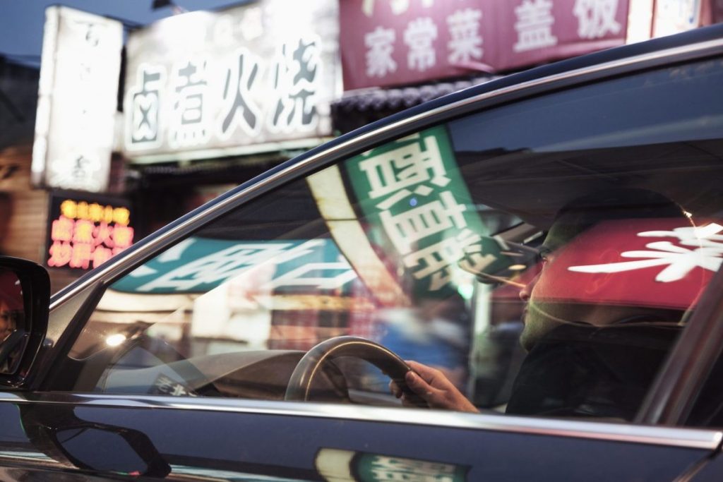 Car service driving the the streets of Beijing at night.